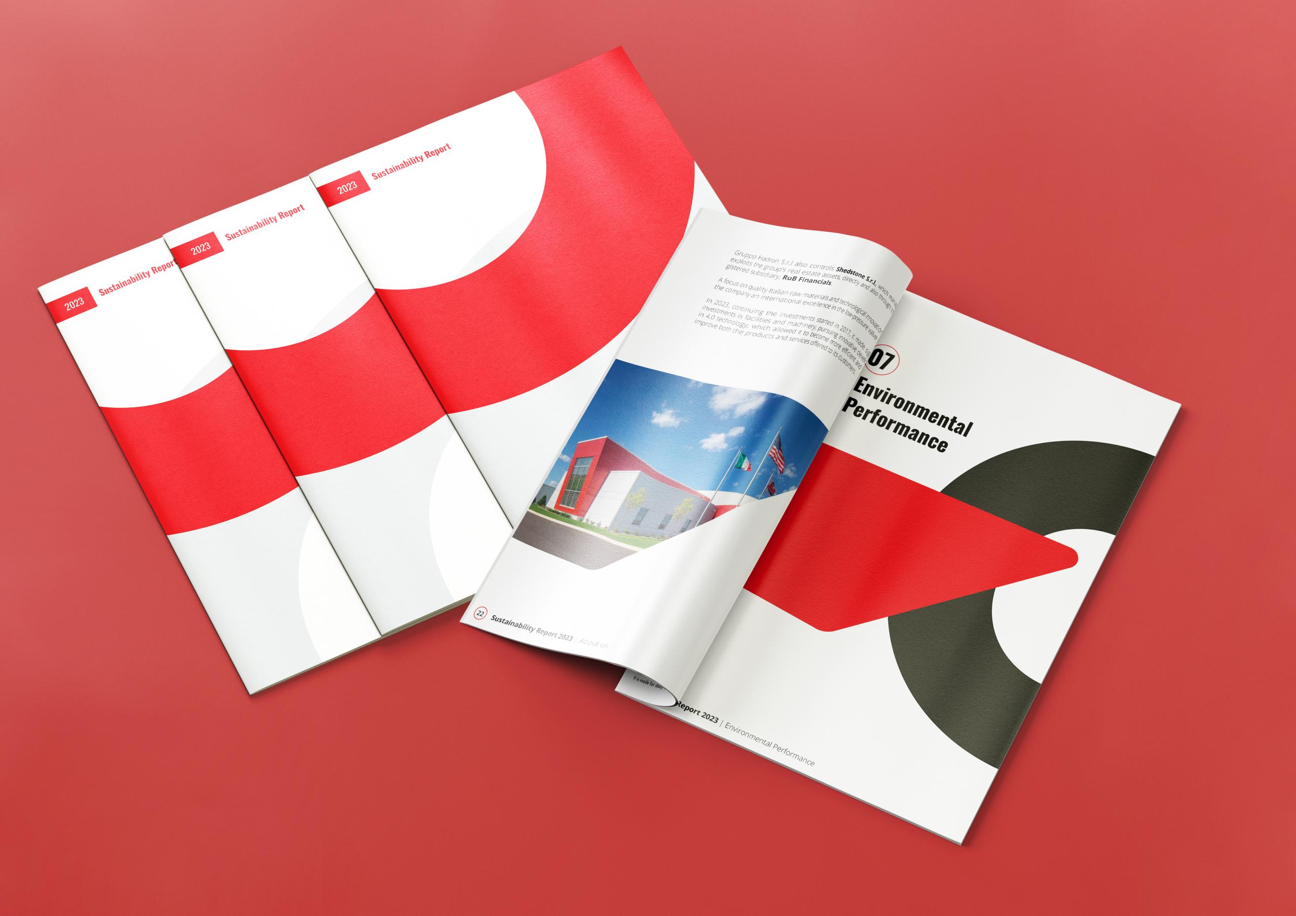 Several copies of Italian Headquarters' 2023 sustainability report displayed on a red background. One of the reports is open, showing a section. Several copies of Italian Headquarters' 2023 sustainability report displayed on a red background. One of the reports is open, showing a section.